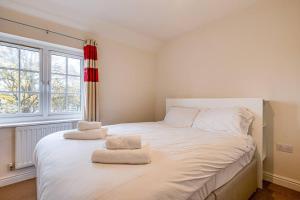 威根Cosy 2 Bedroom Home in Wigan的卧室配有一张白色大床和两条毛巾