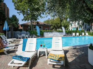 里米尼Dasamo Hotel - Dada Hotels的一组躺椅,位于游泳池旁