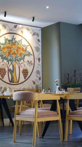 马达巴Aitch Boutique Hotel - an LIH Hotel的用餐室配有木桌椅和绘画作品