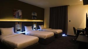 马达巴Aitch Boutique Hotel - an LIH Hotel的酒店客房配有两张床和一张书桌