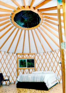 Roan MountainEco Friendly Glamping Yurt In Roan Mountain Tn的圆窗圆顶帐篷内的一张床位