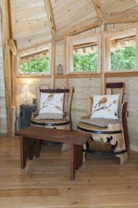 拉沙佩勒奥诺卢瓦尔河畔巴特利尔旅馆的木制客房,配有两把椅子和一张木桌