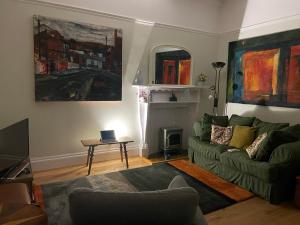 利物浦Airy Apartment Sefton Park的客厅配有绿色沙发和桌子