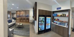 马凯特Holiday Inn Express & Suites Marquette, an IHG Hotel的客厅配有冰箱,备有饮品