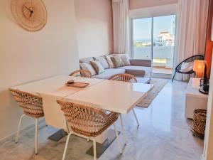 EsteponaSeaview Penthouse Valle Romano Golf的客厅配有桌椅和沙发