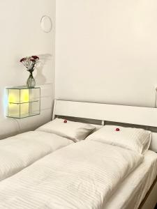 圣加仑Villa Bergruh的两张带白色床单和花瓶的床