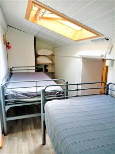 米尼赞海滩A Deux Pas du Courant的小型客房的两张床,设有天花板