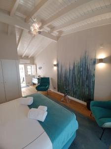 拉戈斯Villa Zawaia B&B的一间卧室配有一张大床和两张绿色椅子
