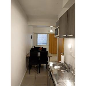 门多萨Shanti Alojamiento Monoambiente y Departamento的一个带水槽和桌子的厨房