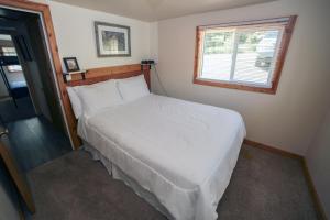 埃斯蒂斯帕克Ponderosa Lodge的卧室内的一张白色床,设有窗户