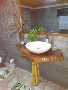 乌图罗阿Ohana Location Ravissant appart spacieux parking gratuit à uturoa的木桌上配有白色水槽的浴室