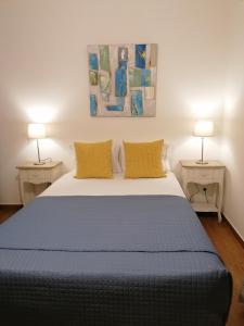 圣巴托洛梅乌迪梅西尼什Guia Guest House的一间卧室配有一张大床和两盏灯