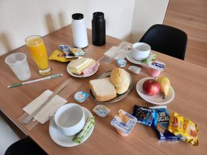 圣保罗For Lovers Jabaquara的一张木桌,上面摆放着早餐食品和饮料