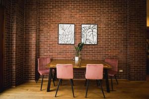 格里利Spacious Loft Over Coffee Shop - Romantic Downtown Escape的一张桌子、粉红色的椅子和砖墙