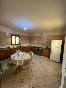 乌姆苏克Djerba Dar BAYA的厨房配有桌椅和冰箱。