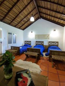 Curuzú CuatiáEstancia San Agustin的一间设有蓝色枕头、桌子和长凳的客房
