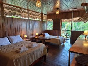 马尔多纳多港Sotupa Eco Lodge的一间卧室配有两张床和两张桌子