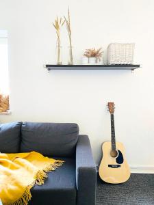 兰讷斯Randers residence Sankt Andreas - 2 room apartment的客厅里带吉他蓝色沙发