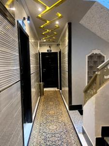 索哈杰Al Amir Palace Hotel的大楼内铺着瓷砖地板的走廊