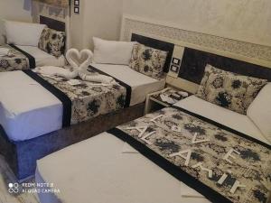索哈杰Al Amir Palace Hotel的一间设有三张床和两张床的房间