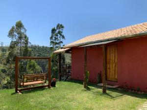 圣安东尼奥-杜皮尼亚尔Chalés Água azul的院子里有长凳的红色房子