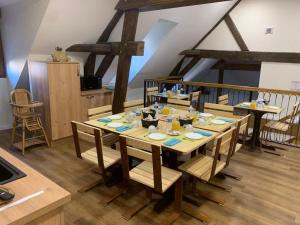 罗斯涅Le Faubourg - Gîte et chambres d'hôte的一间带木桌和椅子的用餐室
