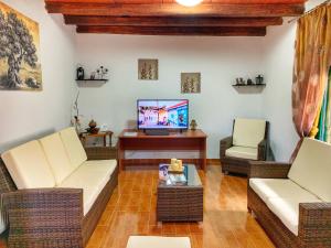 加瓦洛霍里翁Evaggelias Home Gavalochori的客厅配有藤椅和电视