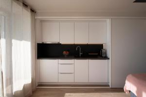 吕特里#Lavaux的厨房配有白色橱柜和水槽