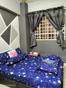 新山Yuyu homestay的一间卧室配有一张带蓝色床单的床和一扇窗户。