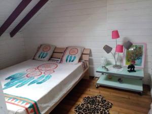 圣克洛德Aux charmes du Saut d'Eau的一间卧室配有一张床和一张带台灯的桌子