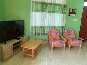 VashafaruArrow的客厅配有两把椅子和电视