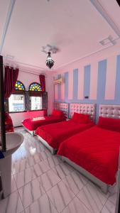 舍夫沙万塞维利亚酒店的一间卧室配有三张床、红色床单和桌子