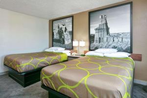 阿马里洛阿马里洛速8酒店的两张位于酒店客房的床,墙上挂有照片