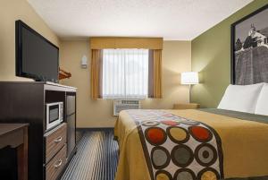 Maysville梅斯维尔速8汽车旅馆的配有一张床和一台平面电视的酒店客房
