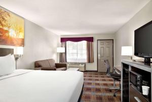 圣安东尼奥Days Inn by Wyndham San Antonio Near Fiesta Park的一间酒店客房,配有一张床和一台电视