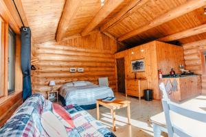 Rock Lake Lodge Provincial ParkRocky Mountain Escape Log Cabin Rentals - Rock Lake的小木屋卧室配有床和沙发