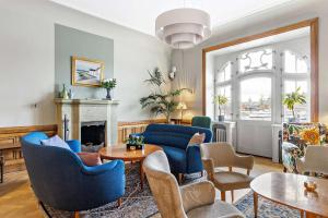 斯德哥尔摩Hotel Esplanade, BW Signature Collection的客厅配有蓝色椅子和壁炉