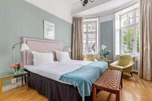 斯德哥尔摩Hotel Esplanade, BW Signature Collection的一间卧室配有一张大床和一把椅子