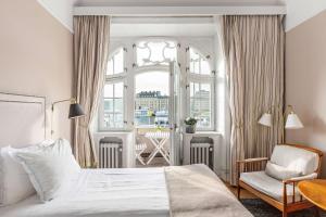 斯德哥尔摩Hotel Esplanade, BW Signature Collection的卧室配有床、椅子和窗户。