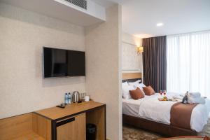 第比利斯Hotel Solum Roof Top的配有一张床和一台平面电视的酒店客房