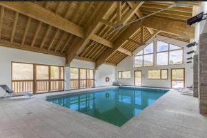 瓦尔Appt Le Hameau Des Rennes 4 étoiles Pieds des pistes Piscine Intérieure Extérieure的一座带天花板的房屋内的大型游泳池