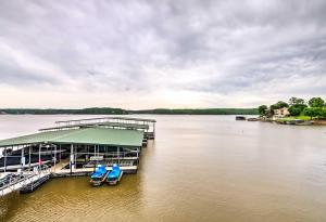 欧塞奇比奇Lakefront Osage Beach Condo Dock Your Boat Here!的湖面上的码头,配有两把蓝色椅子