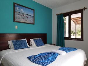 比亚米尔港Hotel LA GRAN TORTUGA - ᯤ STARLINK的一间卧室配有一张蓝色墙壁的床和一扇窗户