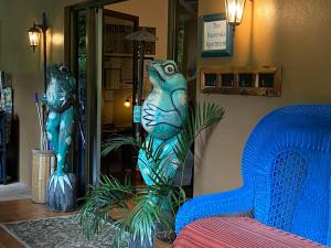 下博克特The Garden Apartment at The Hacienda的一间设有蓝色沙发和两座雕像的房间