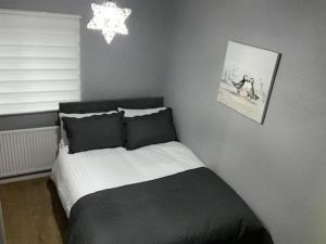 切斯特Ideal Abode Greenfields的卧室配有黑白床和吊灯。