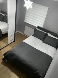 切斯特Ideal Abode Greenfields的卧室配有黑白床和镜子