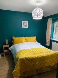 切斯特Ideal Abode Greenfields的一间卧室配有一张黄色的床和蓝色的墙壁