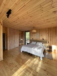 皮奇勒姆奇帕柯山林小屋和简易别墅的一间卧室设有一张床和木制天花板