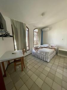 圣路易斯Por do Sol Pousada Praia的卧室配有床、桌子和窗户。