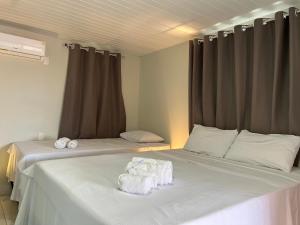 阿廷斯Pousada Solar Maia Costa的一间卧室配有两张带毛巾的床